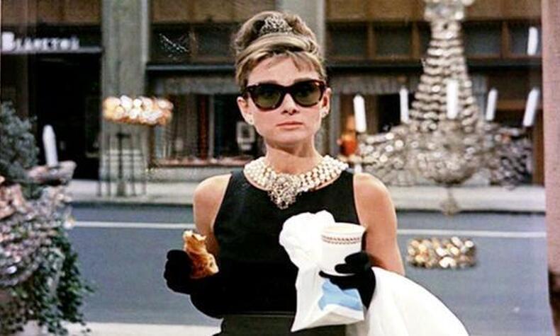 In einer der eindrucksvollsten Szenen des Films frühstückt Audery Hepburn im Morgengrauen, während sie auf das Fenster von Tiffany's blickt. audrey hepburn frühstück mit diamanten