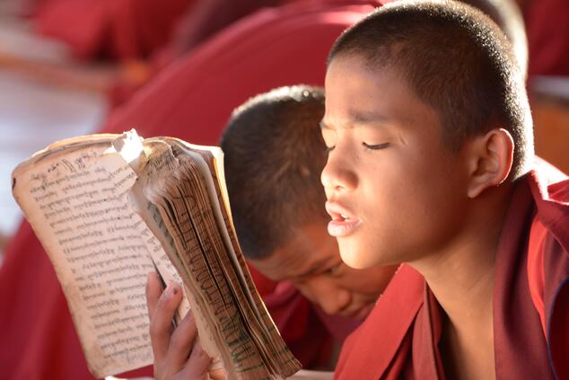 Junger Mönch beim Auswendiglernen von Schriften in Bhutan