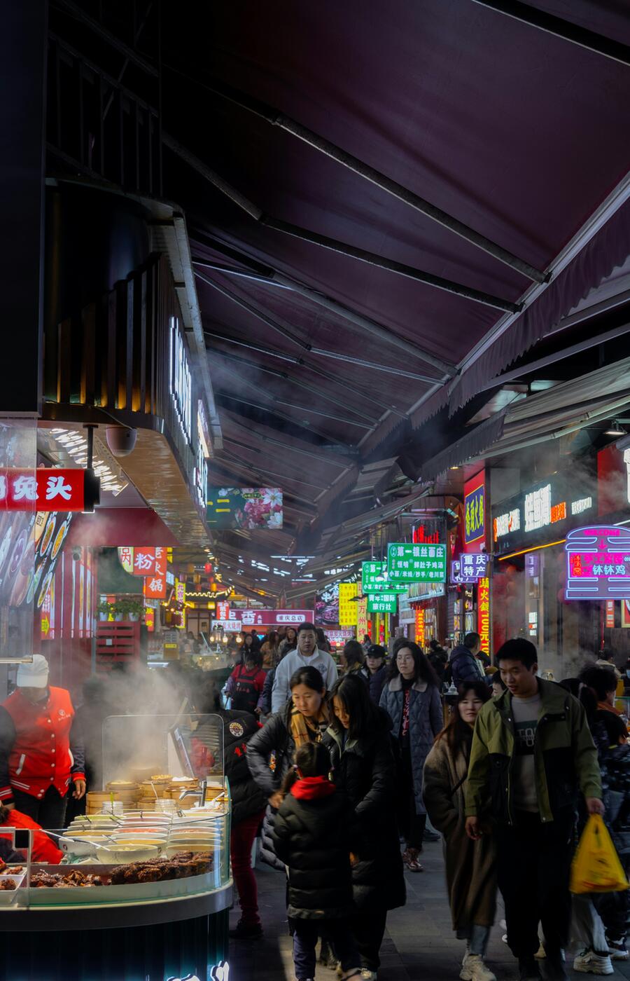 In Chongqing bleiben die Kontraste nicht verborgen: Die Stadt lebt zwischen dem Glanz einer futuristischen Skyline und der Intimität der von roten Laternen beleuchteten Gassen. Zwei Welten, getrennt durch Jahrhunderte... und nur ein paar Schritte. Als ob Blade Runner in einer Geschichte von Lu Xun gelandet wäre. Foto Xiaoyu Xie. Foto Xiaoyu Xie. Chongqing. China.